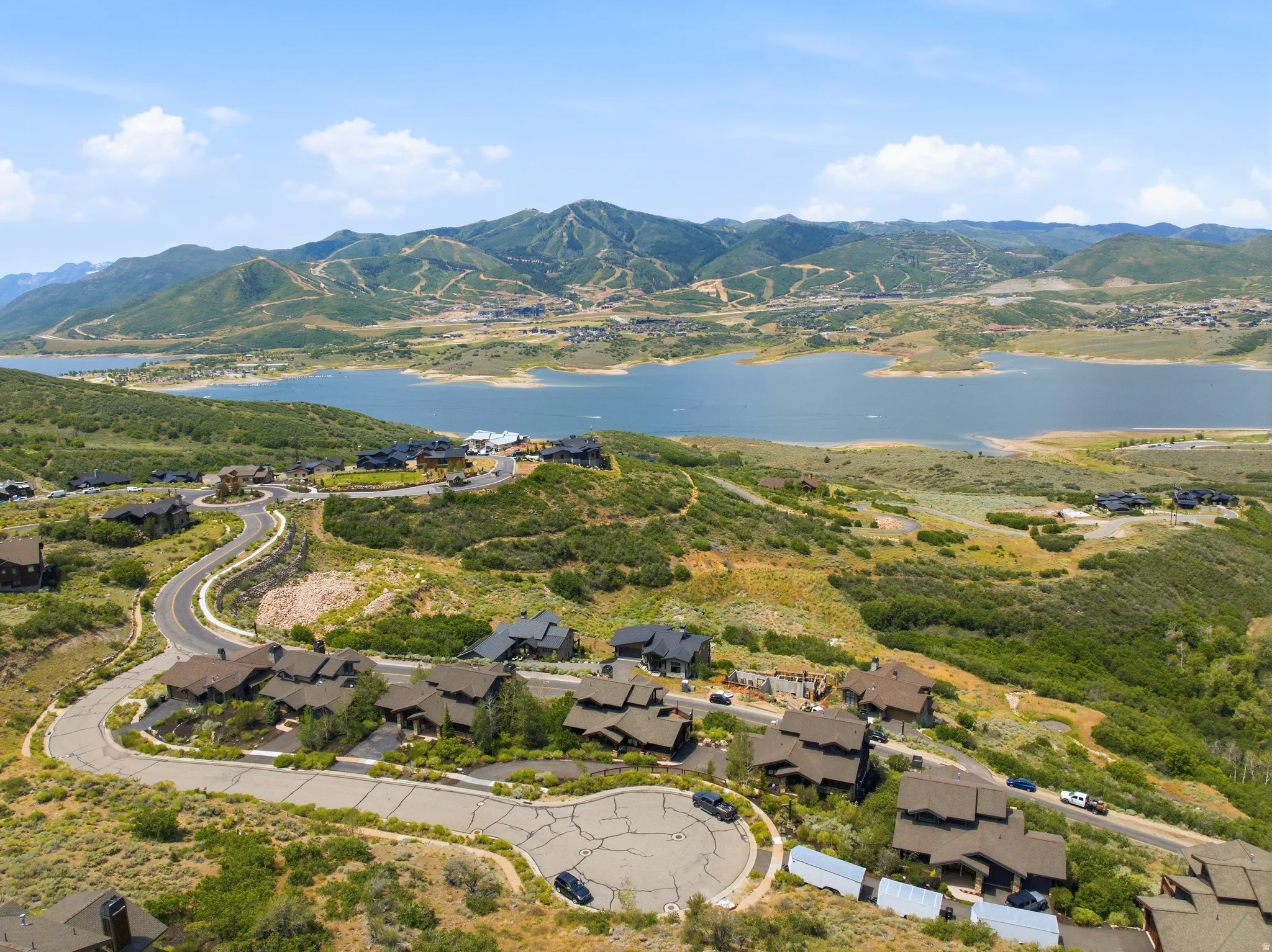 Aerial perspective showcasing a residential area with a prominent lake and mountainous terrain