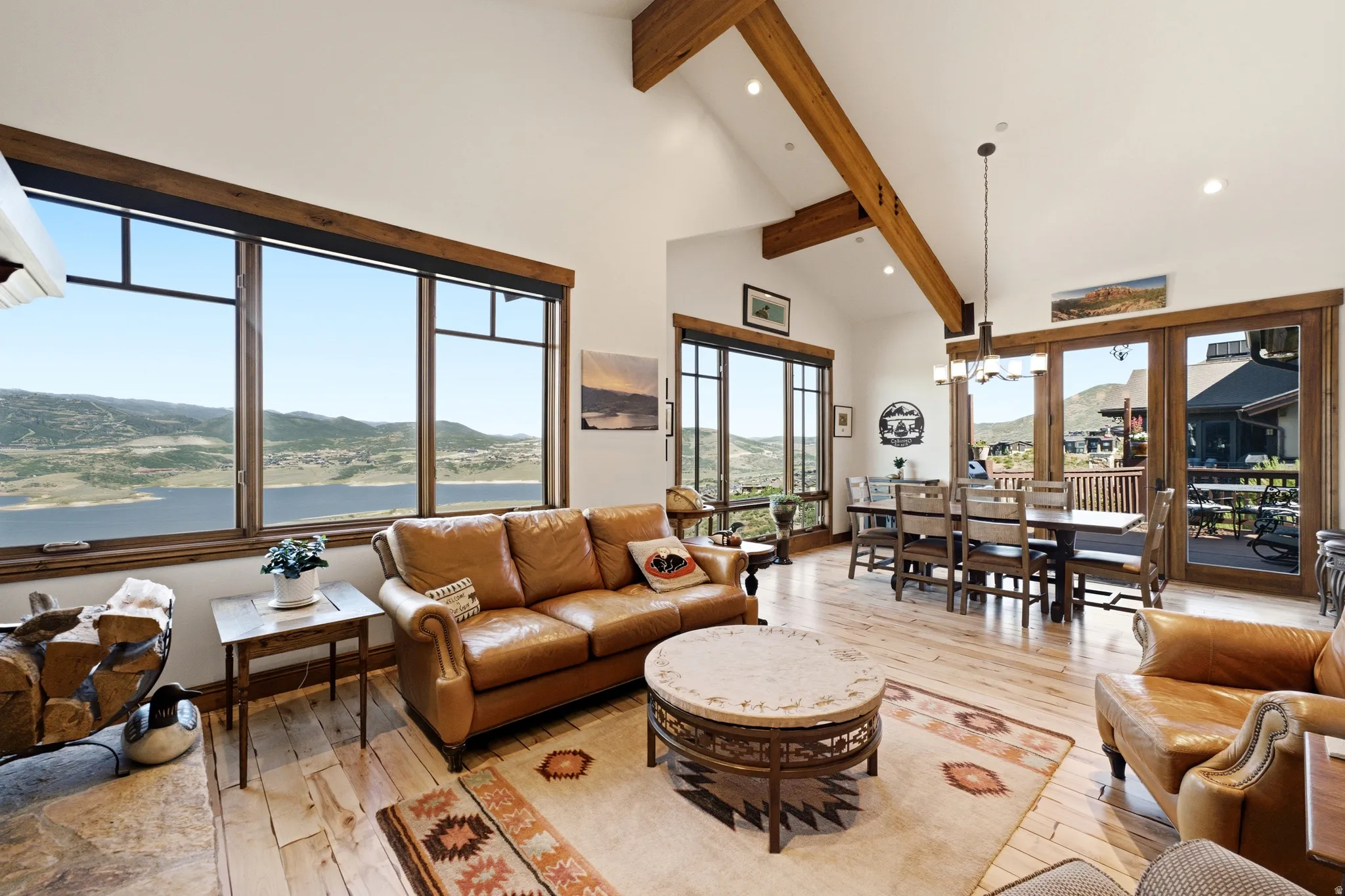 Spacious living area featuring exposed wood beams, vaulted ceilings, and light wood-finish flooring