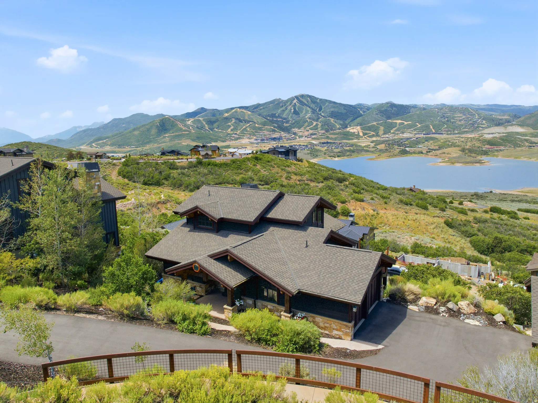 Contemporary multi-level residence featuring a dark wood exterior and natural stone accents