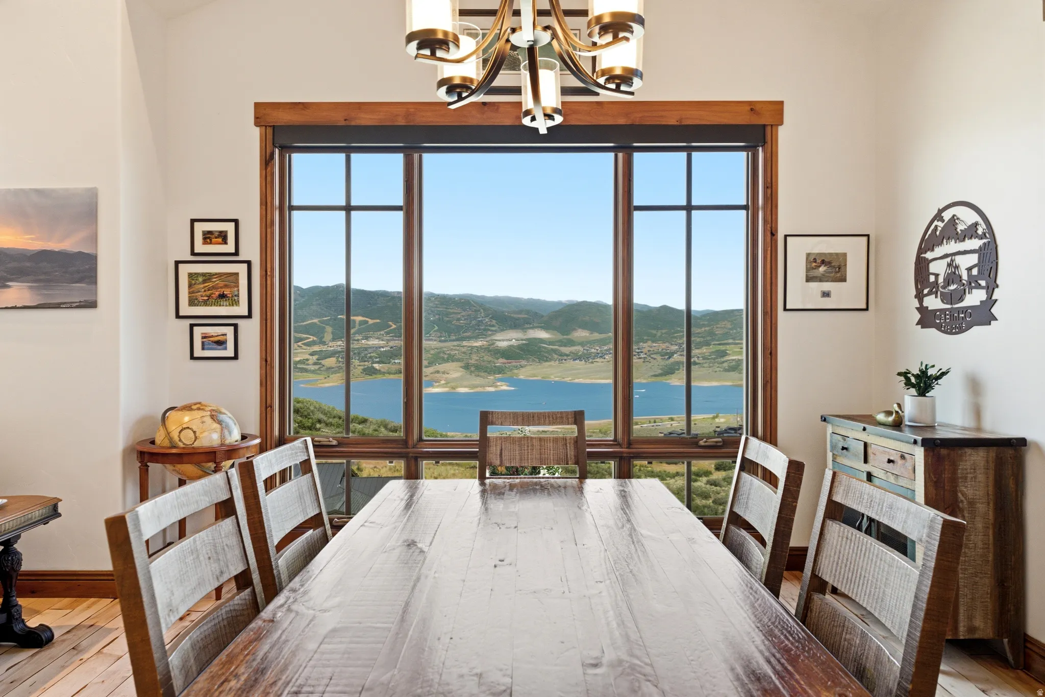 Expansive window overlooking a body of water and distant mountains, featuring natural wood trim and a vaulted ceiling