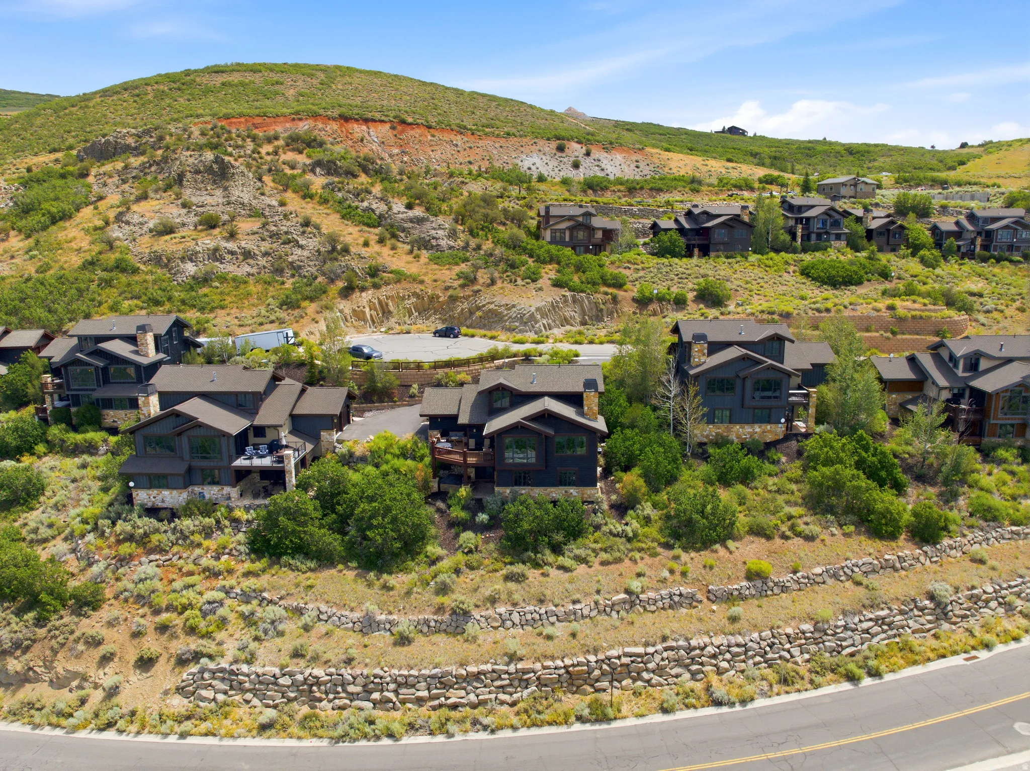 Hillside residential properties featuring dark-toned siding and stone accents