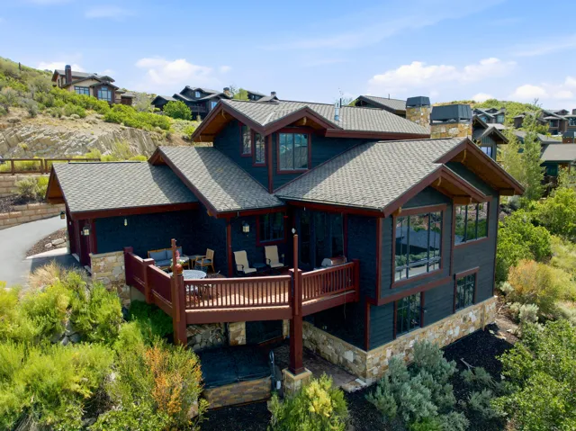 Multi-level residence featuring dark siding with stone accents