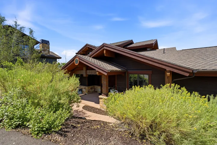 Brown shingled roofline over a dark wood-sided exterior