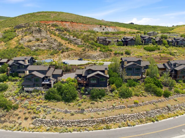 Hillside residential properties featuring dark-toned siding and stone accents
