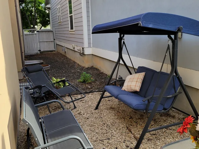 Side yard area featuring gravel ground cover and a wooden privacy fence