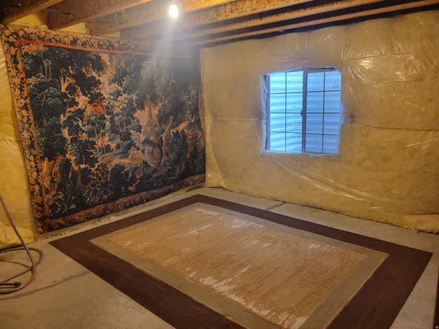 Unfinished lower level featuring exposed ceiling joists, insulated walls, concrete flooring, and a window opening
