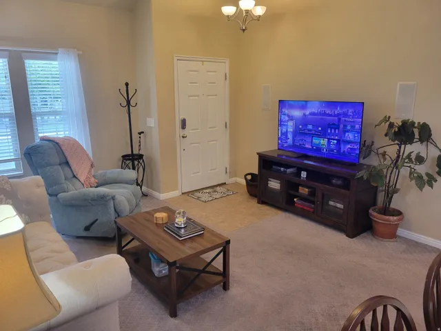 Inviting living area featuring light-toned walls and carpet flooring