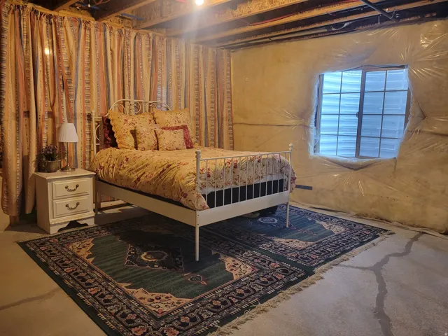 Room featuring exposed ceiling joists, a gridded window, and a concrete floor