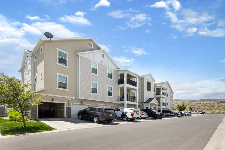 Multi-story residential building featuring light-toned siding and stucco finishes