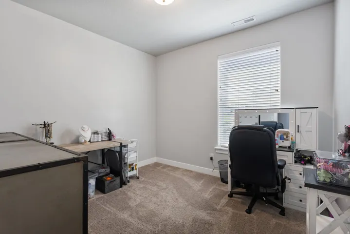 Neutral-toned room featuring a single window with horizontal blinds, light gray walls, and carpet flooring