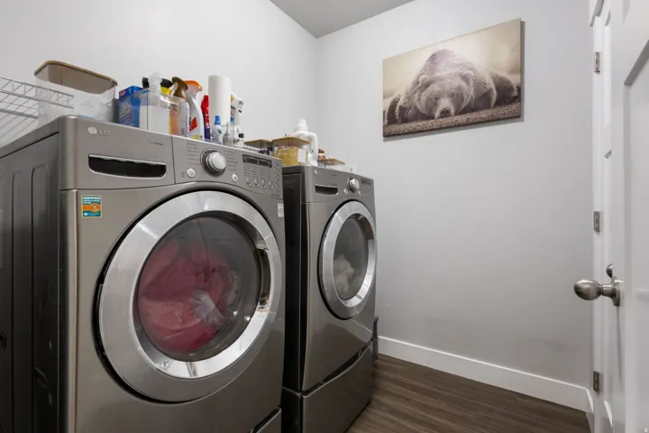 Dedicated laundry area featuring wood-finish flooring