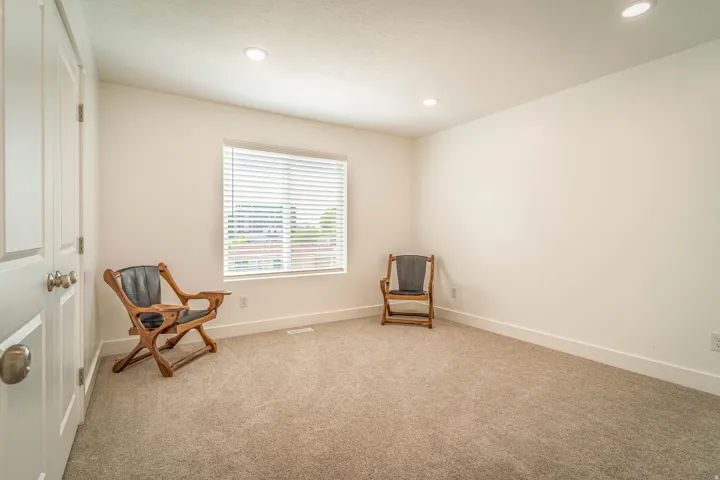 Bright room featuring neutral carpeting and white walls