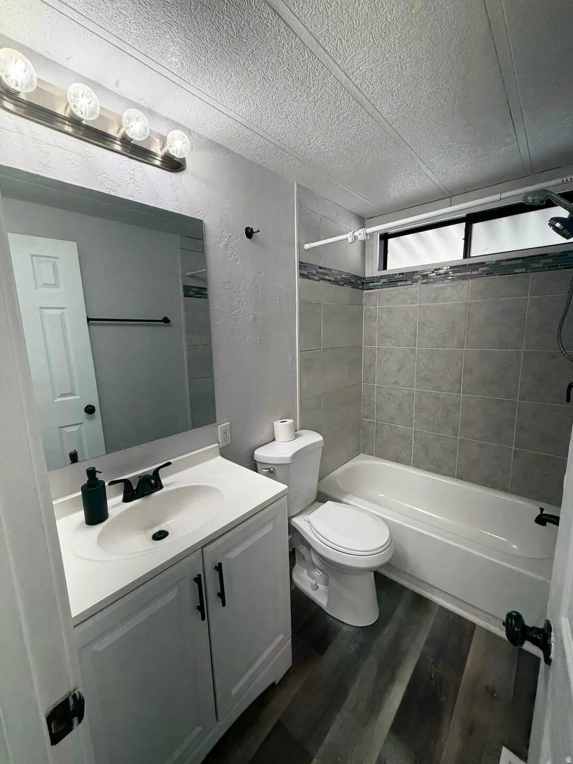 Bathroom featuring a white vanity with a single basin sink, matte black faucet, and white countertop