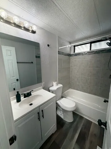 Bathroom featuring a white vanity with a single basin sink, matte black faucet, and white countertop