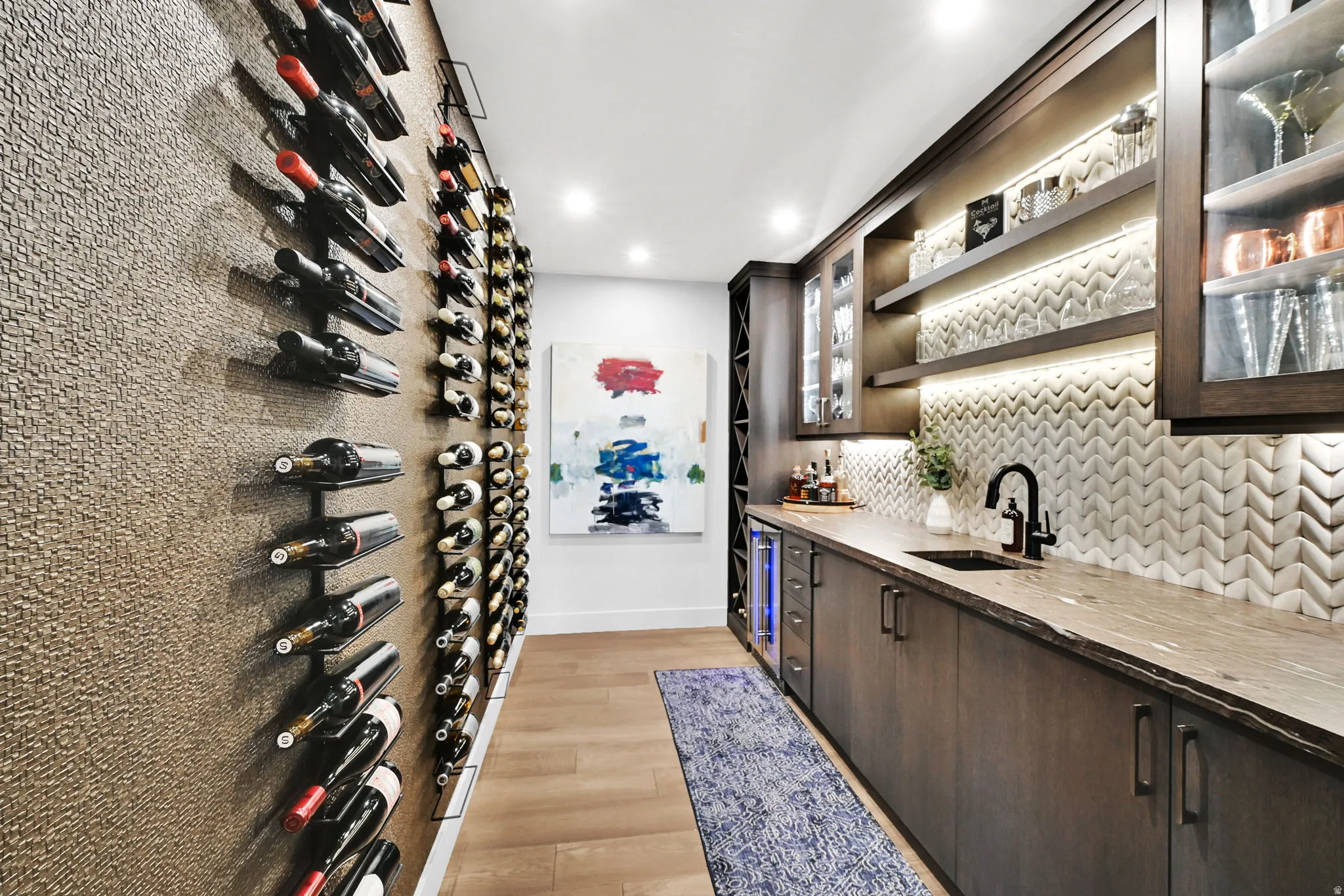 Dedicated beverage preparation area featuring dark wood-finish cabinetry, a stone countertop, and a matte black faucet