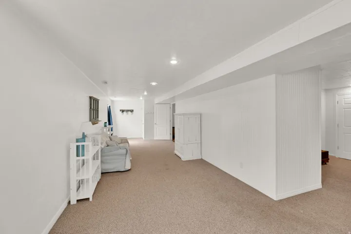 Expansive carpeted room featuring recessed lighting.