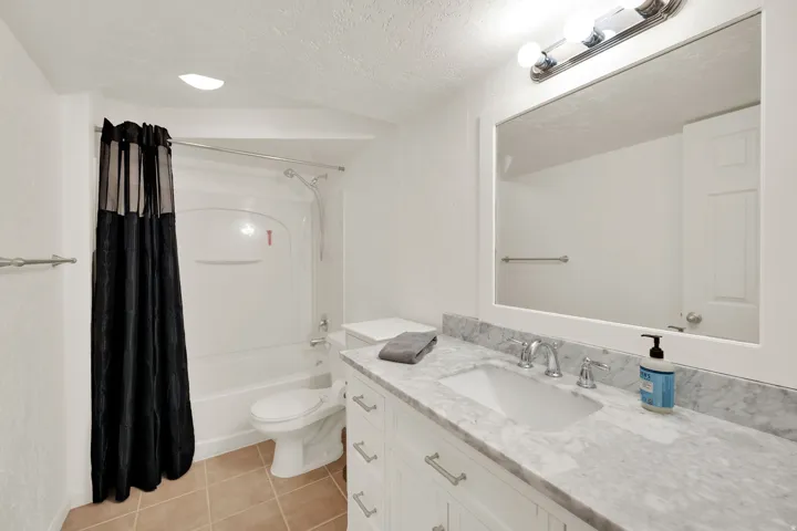 Basement bathroom vanity with new countertop, undermount sink, and chrome fixtures