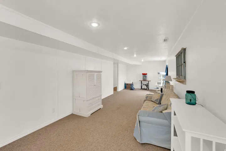 Carpeted recreation room featuring white paneled walls,