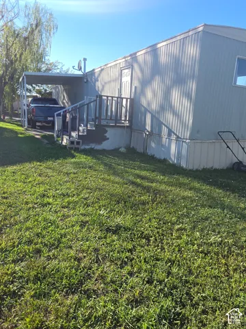 Carport, exterior siding, front entry door, and outdoor steps