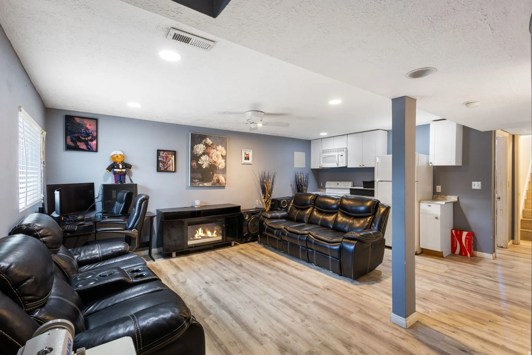 Recreation room featuring wood-finish flooring, recessed lighting, and a built-in electric fireplace