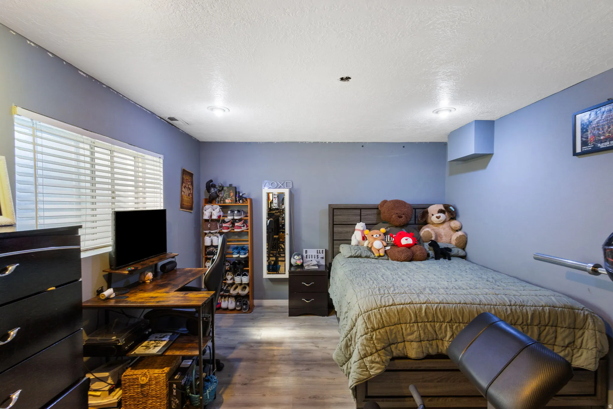 Bedroom featuring wood-finish flooring, recessed lighting, and a window with horizontal blinds
