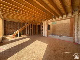 Open concept framing featuring exposed ceiling joists, a framed staircase, and an unfinished subfloor
