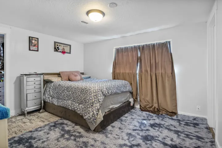 Bedroom with white walls, a single window, and a flush mount light fixture