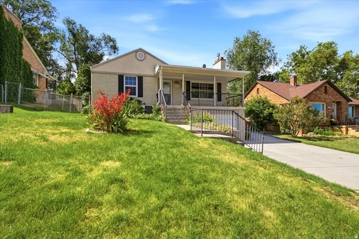 Front exterior featuring a covered porch, established landscaping, and a concrete driveway