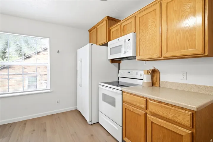 Kitchen featuring wood-finish cabinetry and light-toned countertops