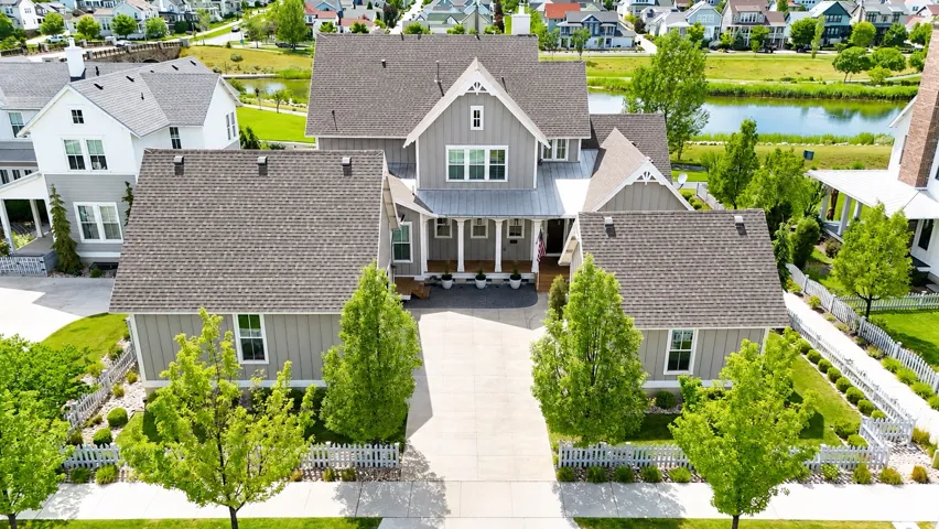 Expansive property featuring gray asphalt shingle roofing, mature landscaping, and concrete driveway