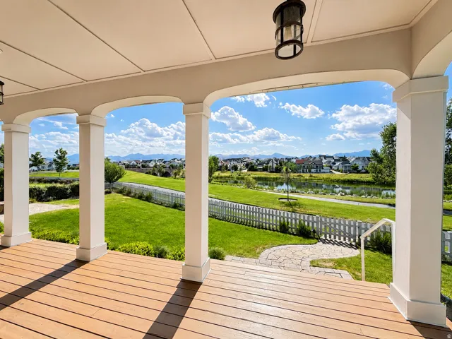 Covered porch with wood-finish decking, supported by architectural columns with arched soffits