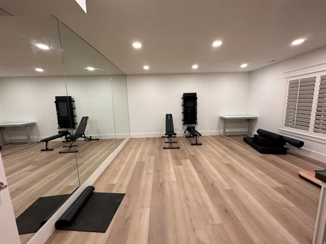 Exercise/Dance room featuring a full wall of mirrors and wood flooring