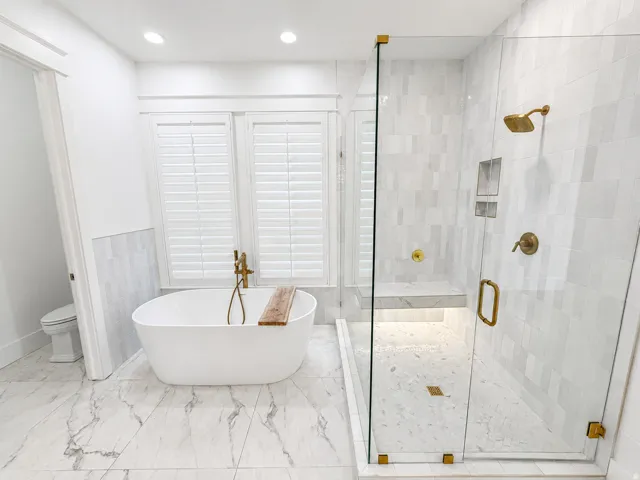 Soaking tub, glass-enclosed shower with rain head and built-in shower bench