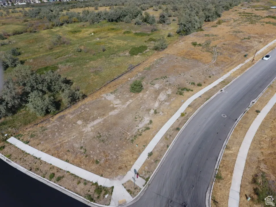 Corner parcel featuring a paved road with concrete sidewalks