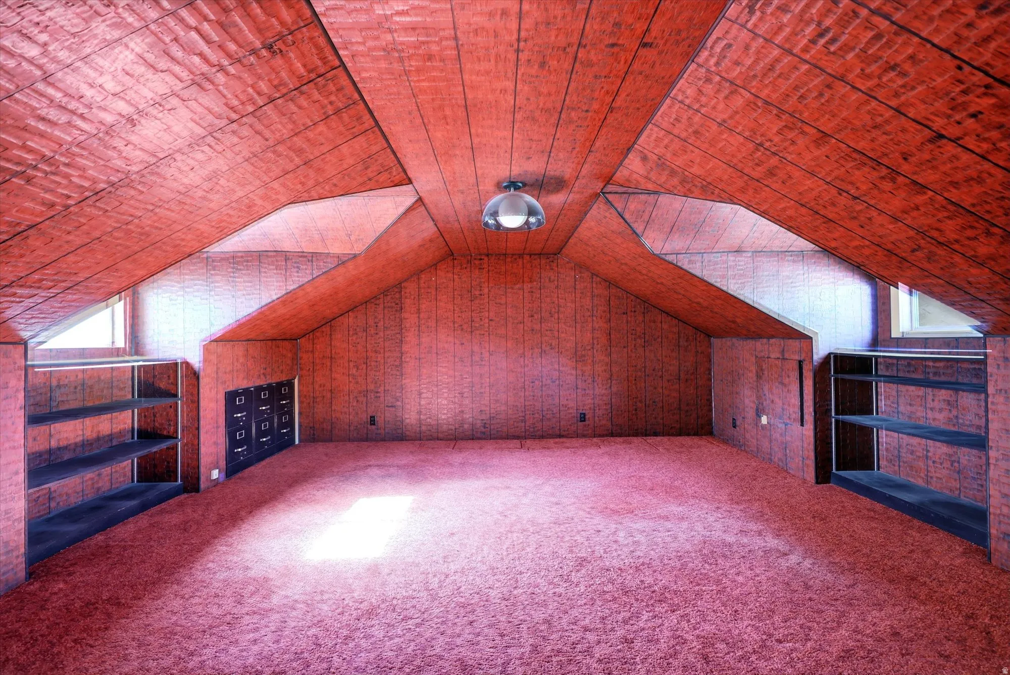 Attic room featuring sloped ceilings, paneling, and wall-to-wall carpeting