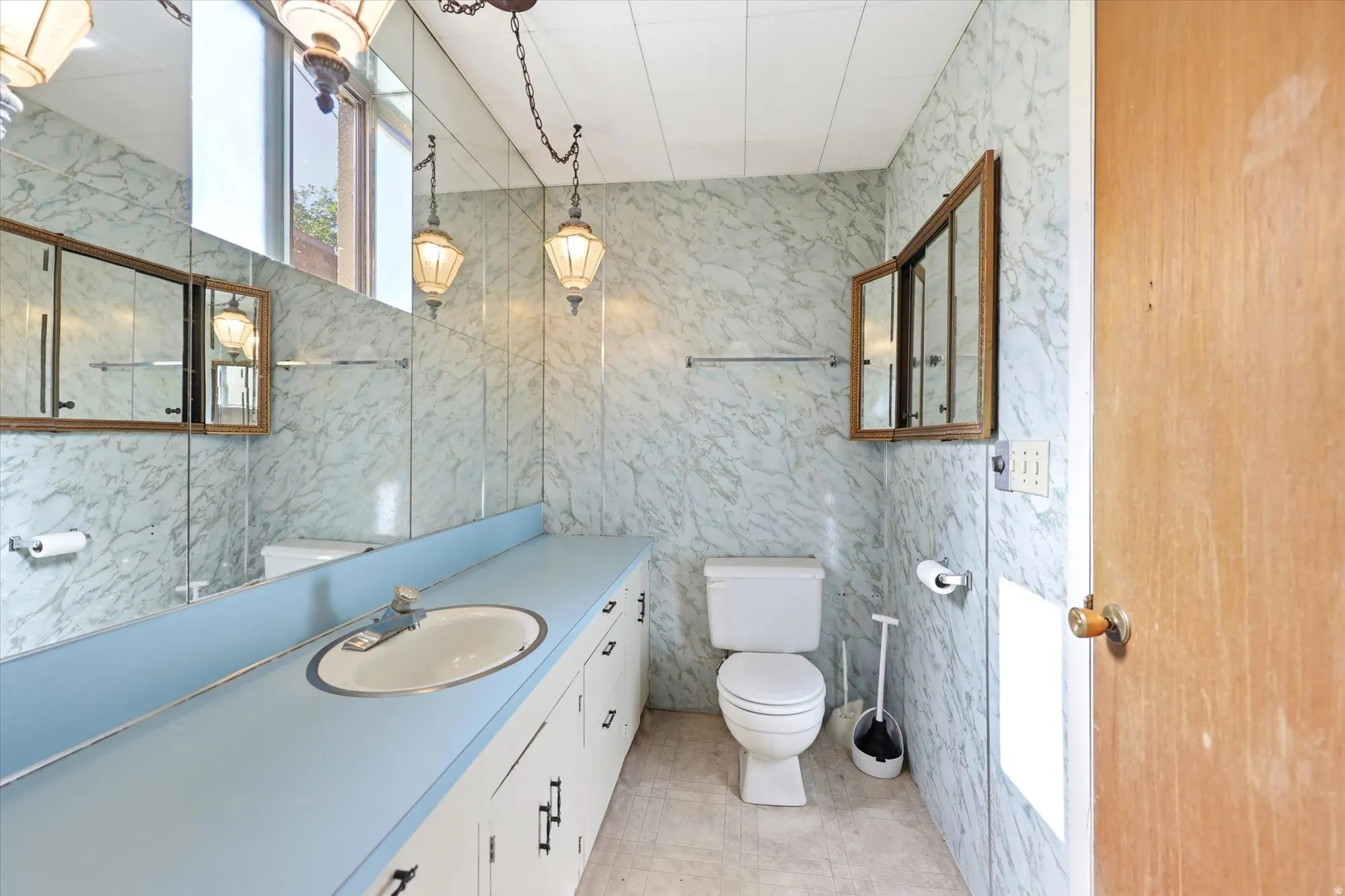 Bathroom featuring a vanity with a blue countertop, integrated sink, and white cabinetry
