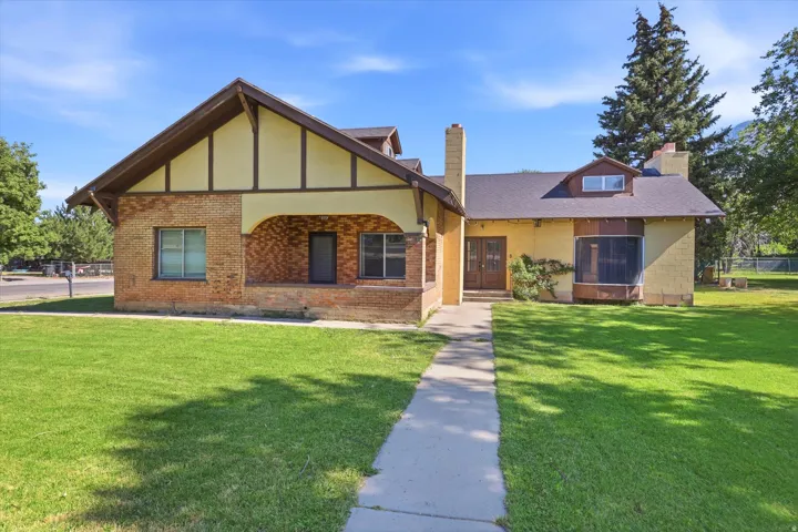 Brick and stucco exterior featuring gabled rooflines, an arched brick entry, and a front walkway