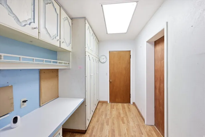 Integrated desk space featuring overhead cabinetry, wood-finish flooring, recessed lighting, and a neutral color palette