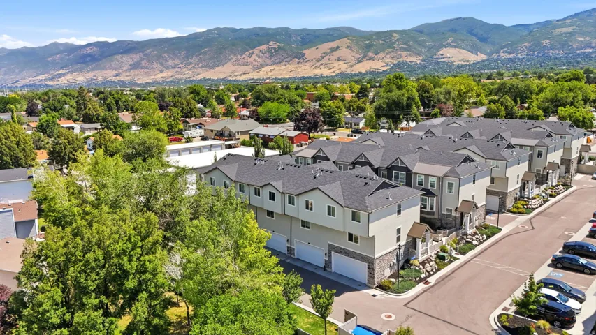 Contemporary townhome development featuring multi-level facades, integrated garages, and dark grey shingle roofs