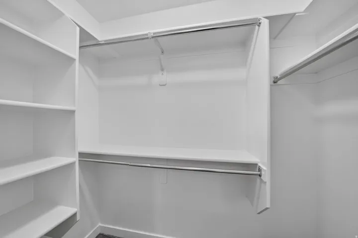 Built-in closet system featuring multiple shelving units and chrome hanging rods
