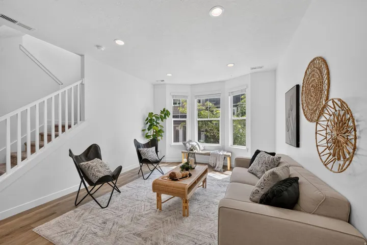 Living area featuring wood-finish flooring, recessed lighting, and a prominent bay window