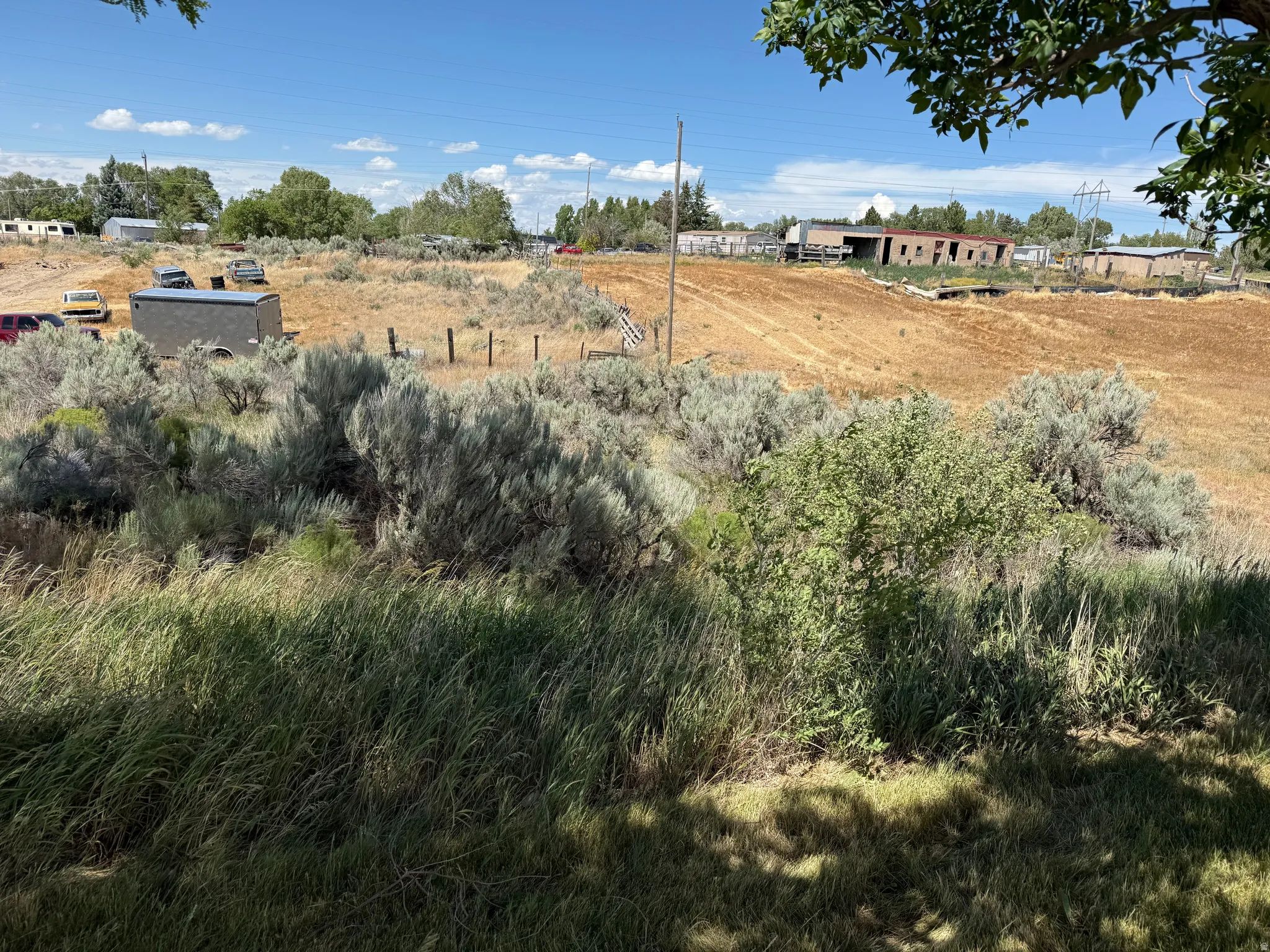 Expansive undeveloped land featuring natural vegetation and open fields under a clear sky