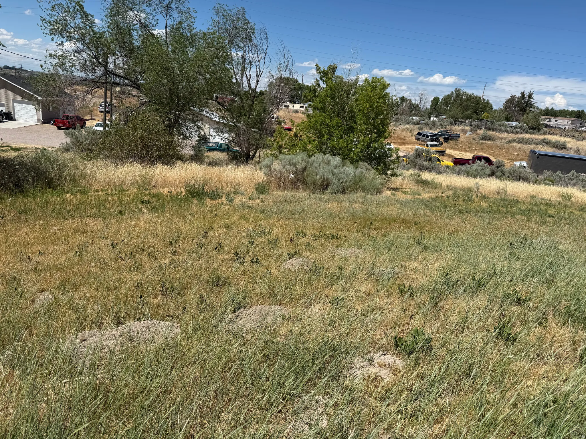 Expansive open lot featuring natural vegetation and varying terrain
