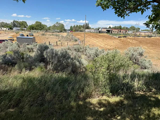 Expansive undeveloped land featuring natural vegetation and open fields under a clear sky