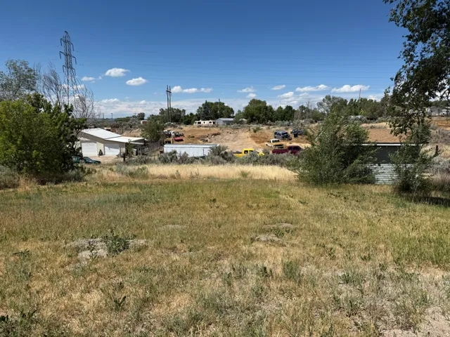 Expansive outdoor space featuring varied terrain with natural growth and areas of sparse vegetation