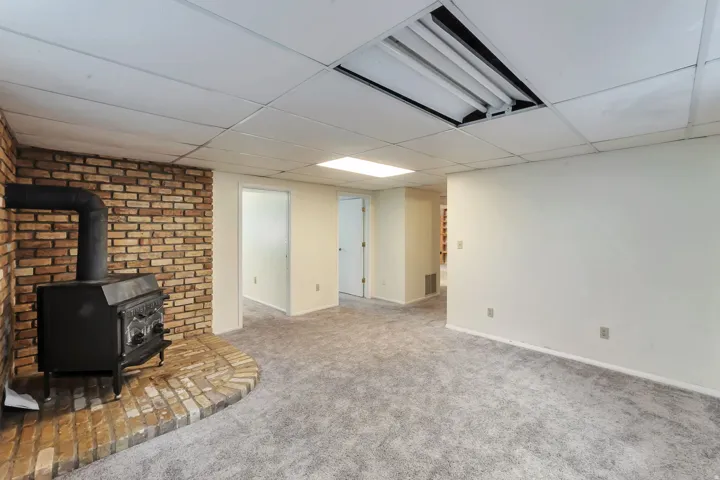 Exposed brick accent wall with a black wood-burning stove on a brick hearth
