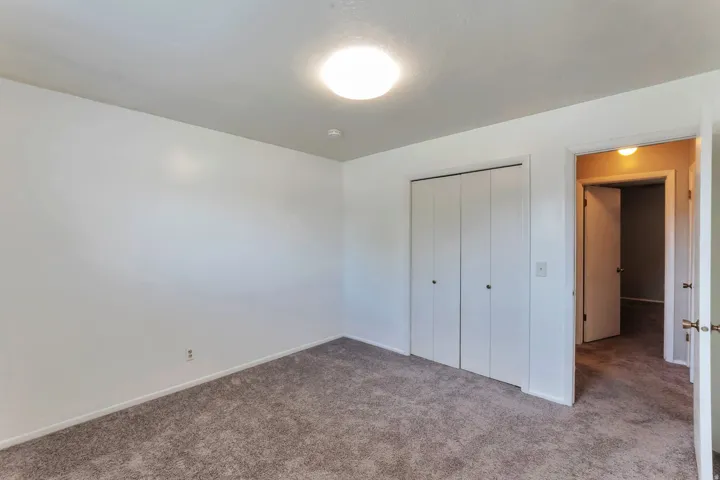 Room featuring wall-to-wall carpeting, white walls, and a ceiling-mounted light fixture
