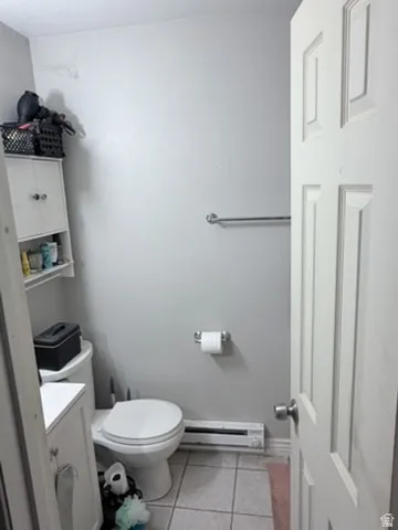 Powder room featuring a white paneled door, light gray walls, and tile flooring