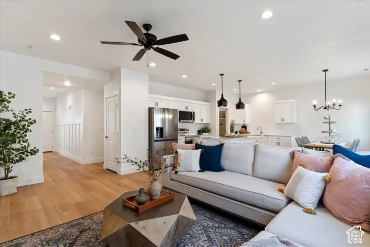 Spacious open-concept living area featuring wood-finish flooring, recessed lighting, and a contemporary ceiling fan