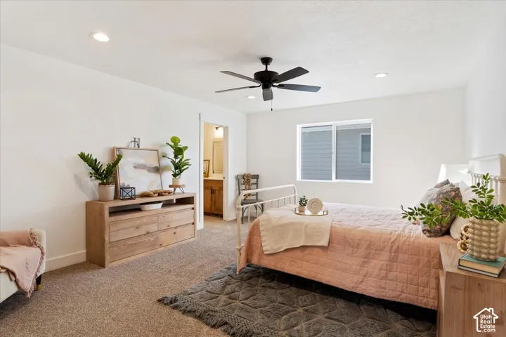 Carpeted bedroom featuring recessed lighting, a modern ceiling fan, and a window with white trim